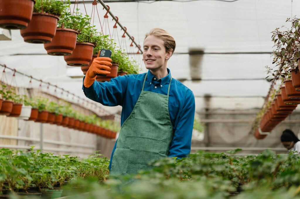 man using a cellphone inside a green house